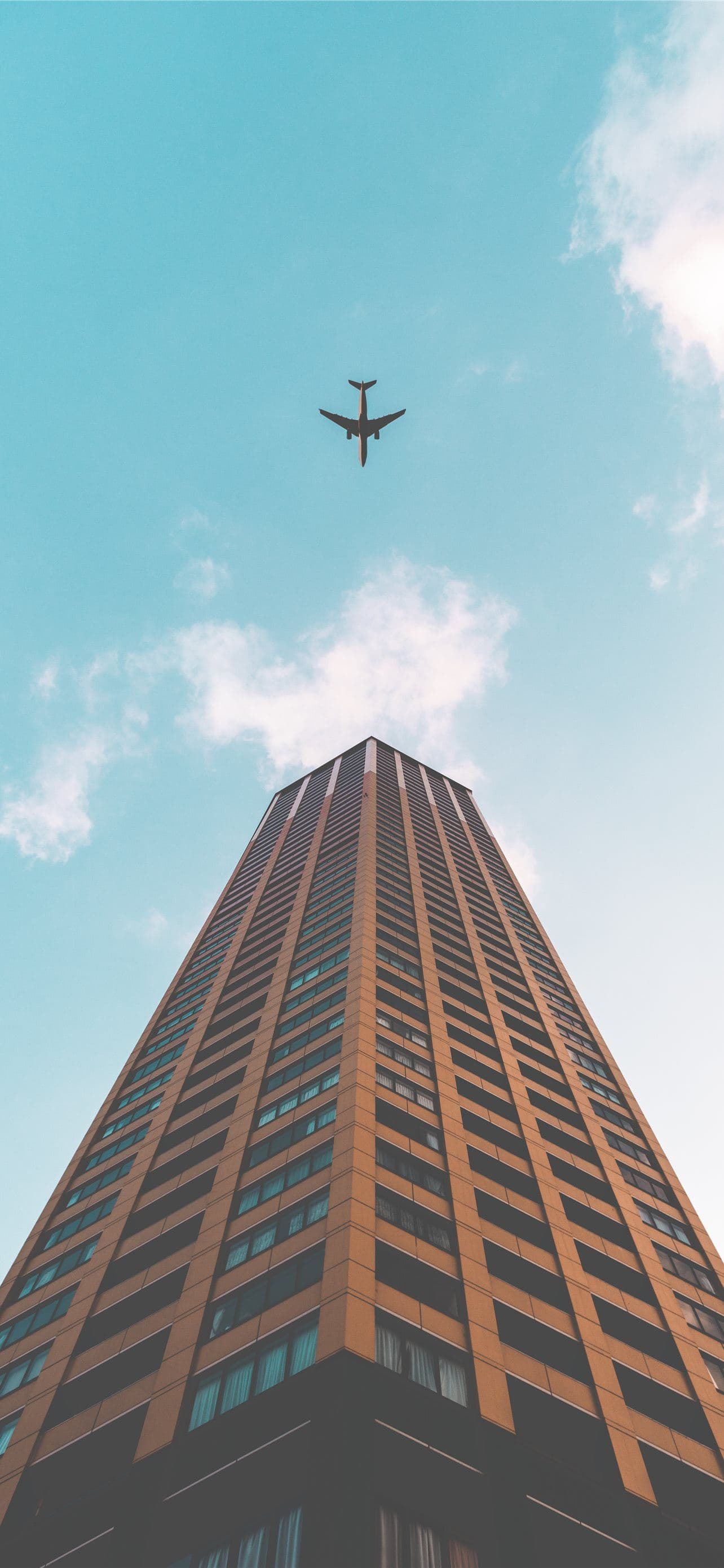 Bottom View Shot Of Airplane Flying Above High Ris